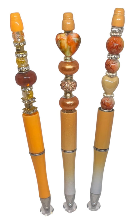 Orange Australian Crystal Beads and heart ceramic beads and gems beaded beautifully on a bead-able refillable pen