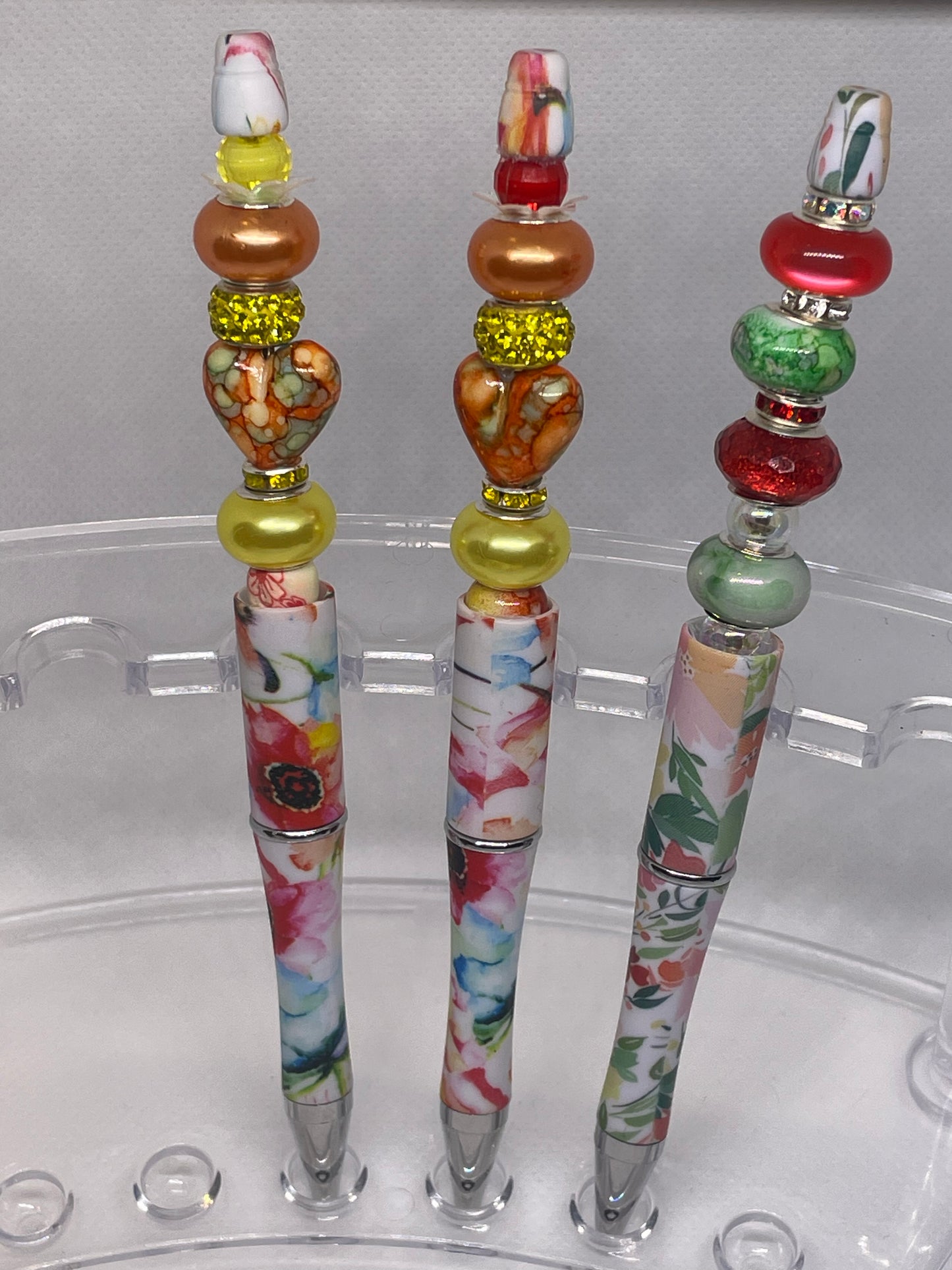 Close-up of a floral beadable pen with heart and metallic accents, designed for elegance.