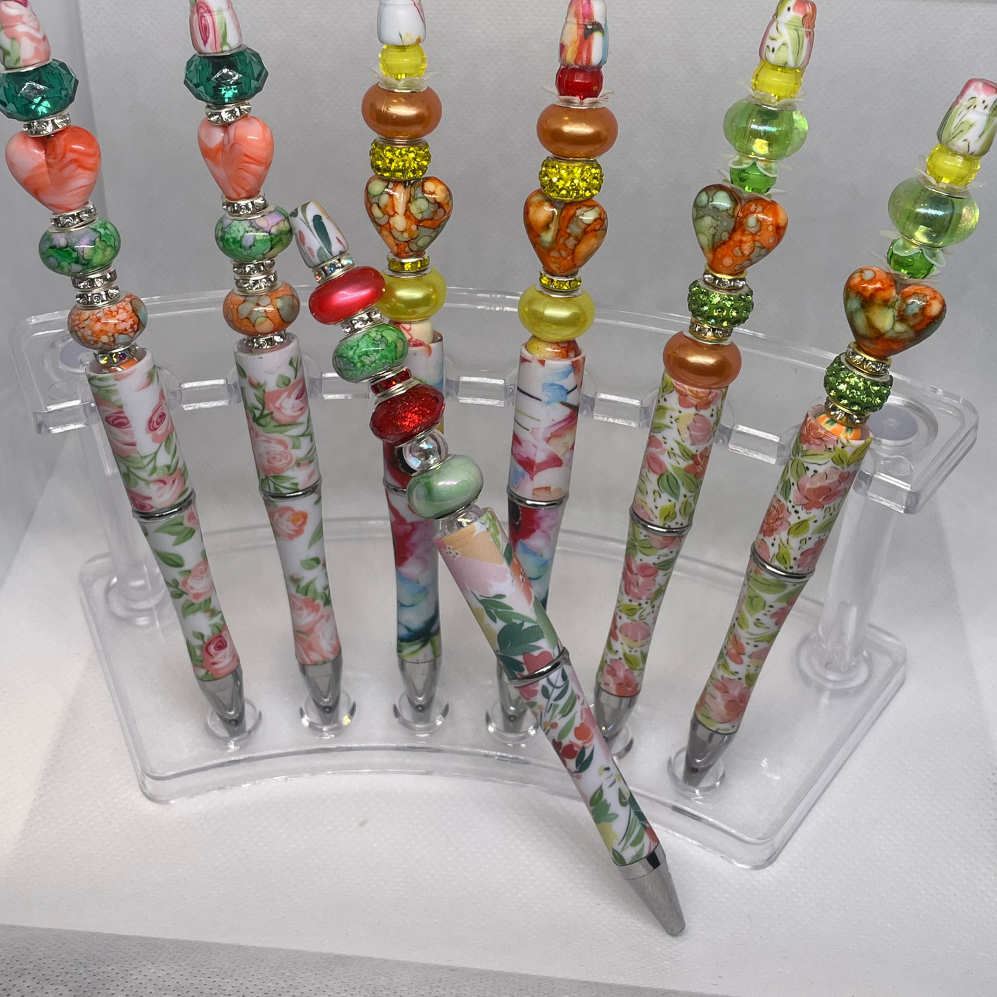 Beaded pen with peach and green floral accents and heart-shaped beads.