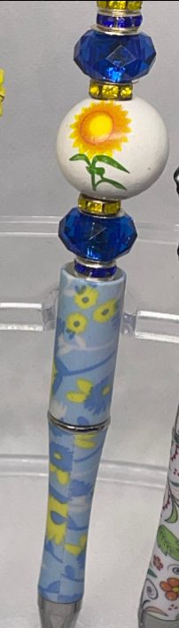 "Sunflower beaded pen with yellow and blue floral accents for a cheerful writing experience."